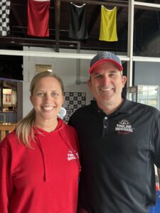 Eric and Meggan Page, owners of Fowling Warehouse Indianapolis, standing together inside the venue, creating a welcoming, community-focused space for guests to connect and enjoy Fowling.