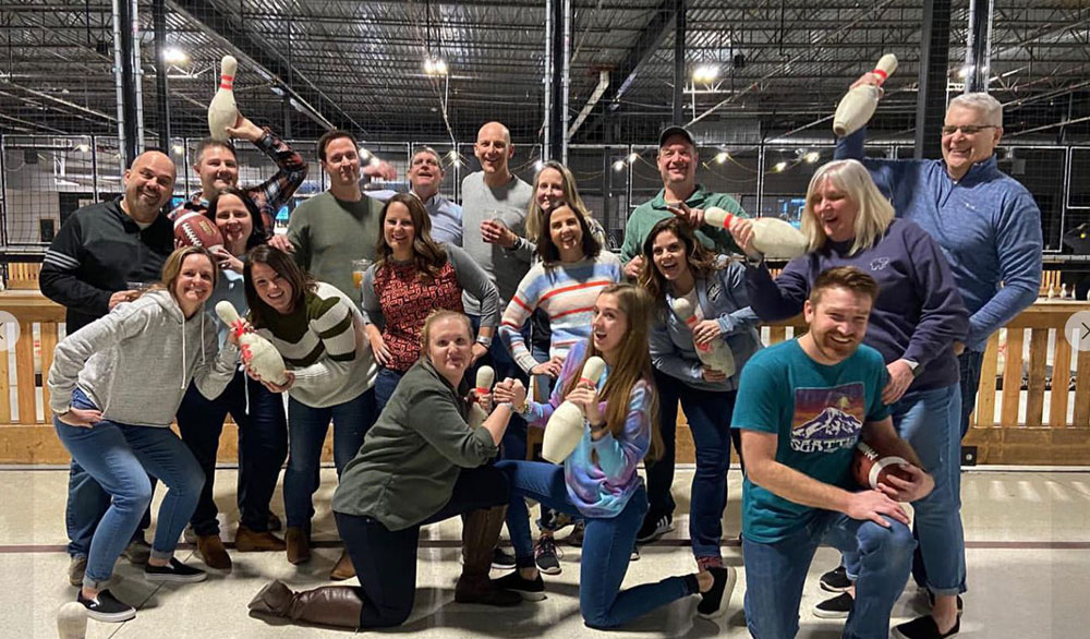 A group of people holding up pins laughing an posing for the camera