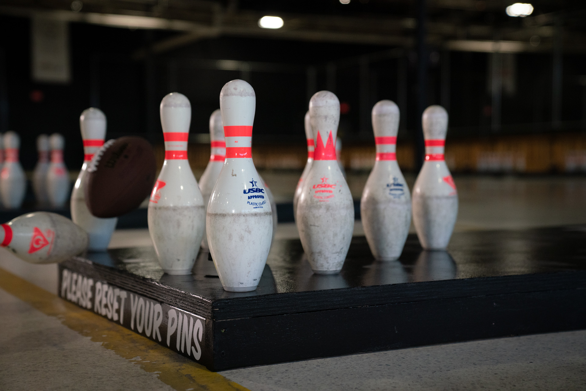 Football hitting bowling pins set up on a platform